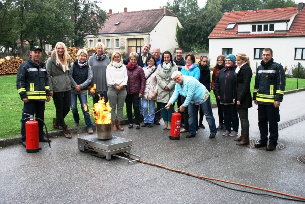 Lehrkräfte und Kindergartenpersonal üben sich mit Feuerlöschern